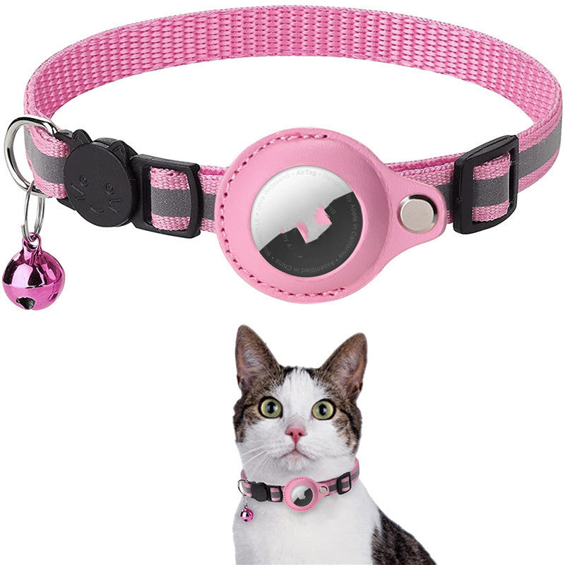Pink and gray pet collar with a bell and a small round device, worn by a cat.